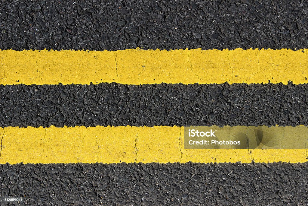 Urban texture double yellow lines on street An urban texture representing double yellow lines on a road. NO STOPPING. Horizontal. City Stock Photo