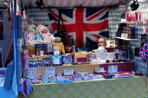 london, england - November 17, 2012: person is selling british flag and british presents at open market near picadilly circus of london england