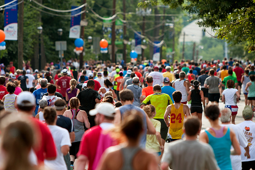 Atlanta, GA, USA - July 4, 2014:  Thousands of runners crowd an Atlanta street on their way to the finish line of the Peachtree Road Race.