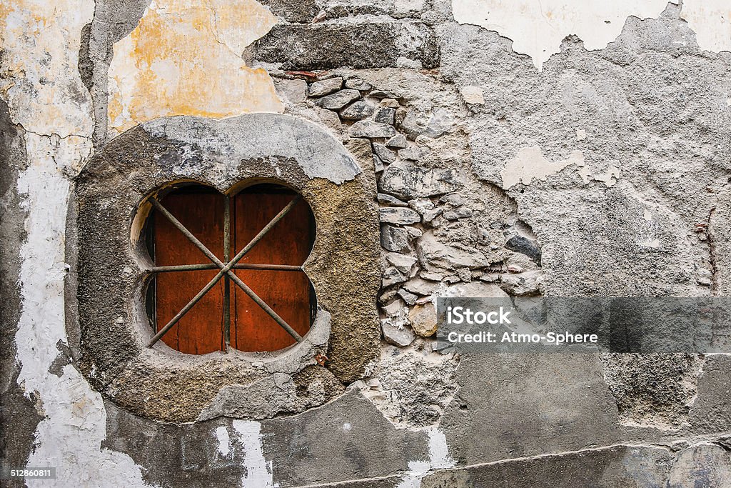 Grungy Madeira wall with clover-shaped window and steel bars Abandoned Stock Photo