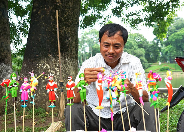 Vietnam traditional toy Ha Noi, Viet Nam - July 13, 2014: An unidentified craftsman doing TO HE (Vietnam traditional toy) for children in Hanoi. This is a tradition of Vietnamese in Lunar New Year vietnamese girls for sale stock pictures, royalty-free photos & images