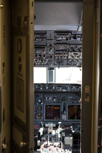 View through an open security door into the cockpit of a Boeing 737