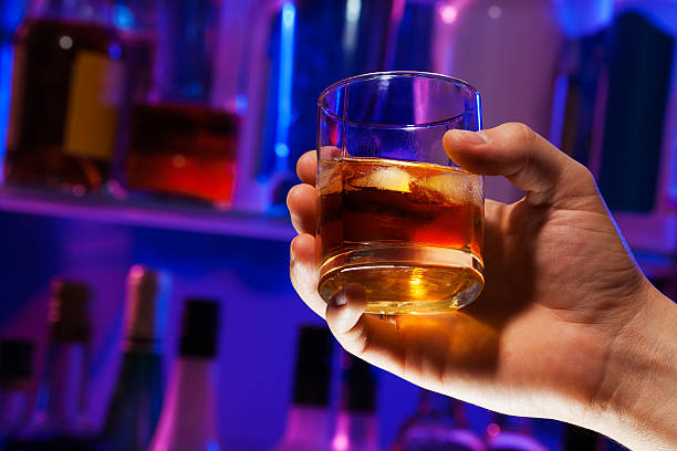 istock Man hand with whiskey glass in bar 512882596