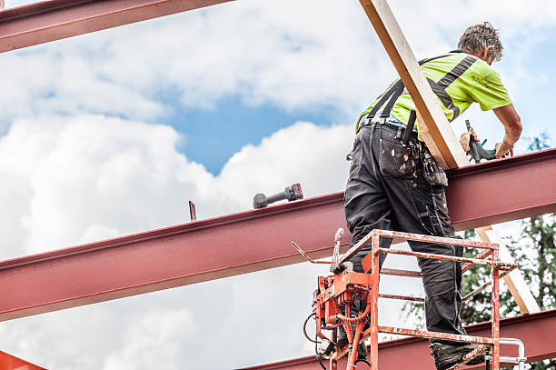 istock Man on sky lift working on roof beams 512883318