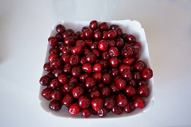 istock Delicious red cherries in white plate 512885342