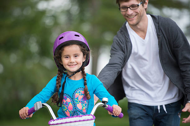 istock Daughter Learning How to Ride a Bike From Her Dad 512887410