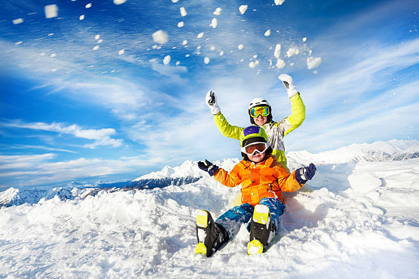 Mother and son on the mountain happy throw snow stock photo