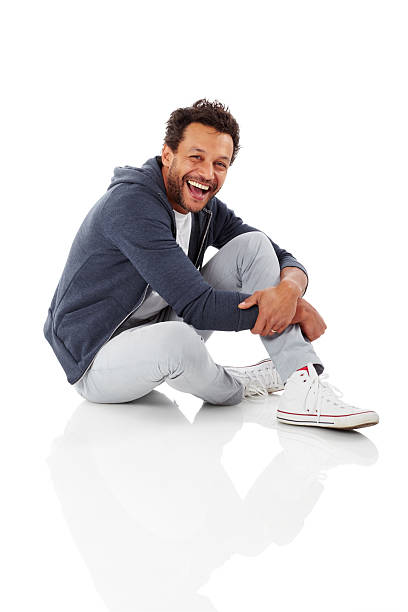 retrato de hombre africano alegre sentado en blanco - one floor fotografías e imágenes de stock