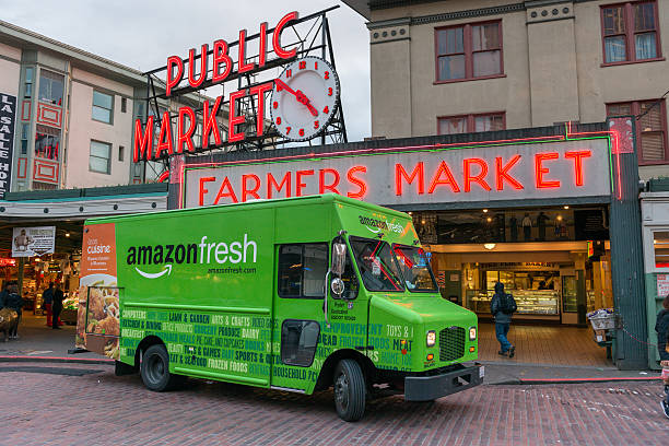 Pike Place Market Seattle, USA - February 2, 2016: An Amazon Fresh truck in front of the famous Pike Place Market late in the day. elliott bay photos stock pictures, royalty-free photos & images
