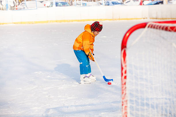 istock Little boy play ice hockey outside 512889624