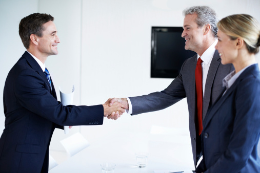 Shot of two businesspeople shaking hands in an office