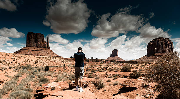 istock tourist standing against the monument valley landscape 512892164