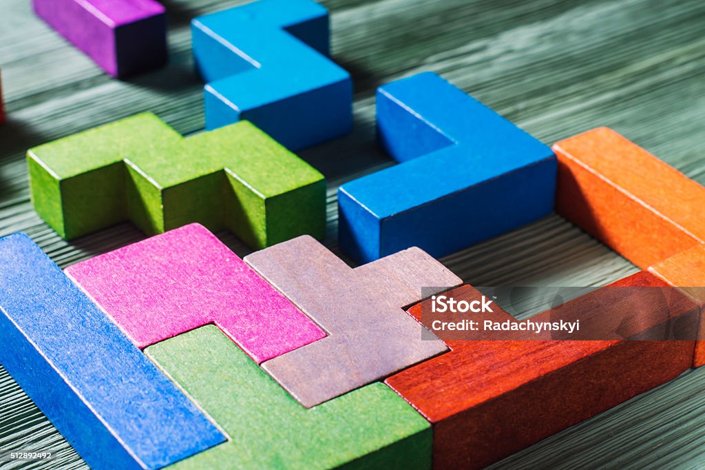 Geometric shapes on a wooden background. The concept of logical thinking. Geometric shapes on a wooden background.  game toy wooden blocks. Toy Block Stock Photo