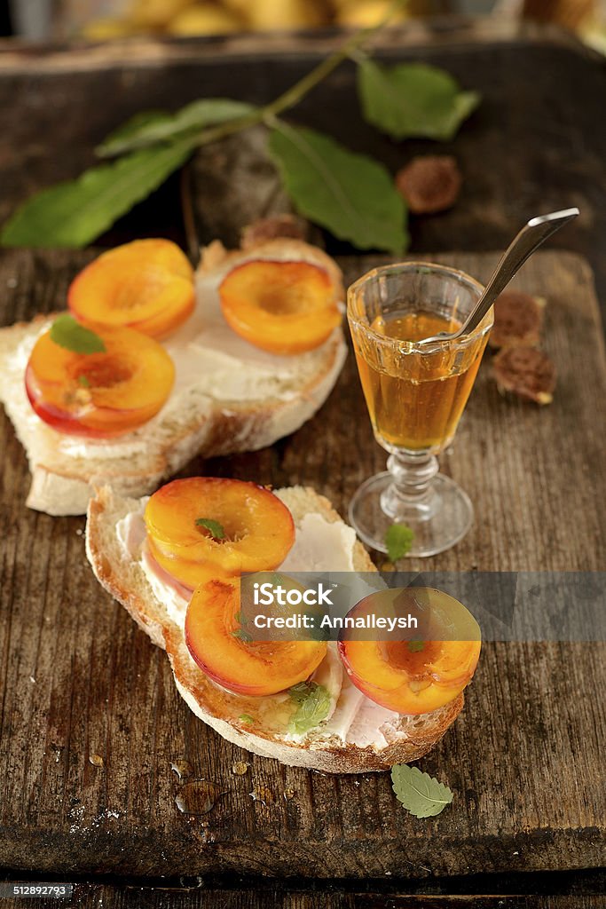 open sandwiches with peach and honey Crostini with Peaches and honey on the rustic wooden desk Appetizer Stock Photo