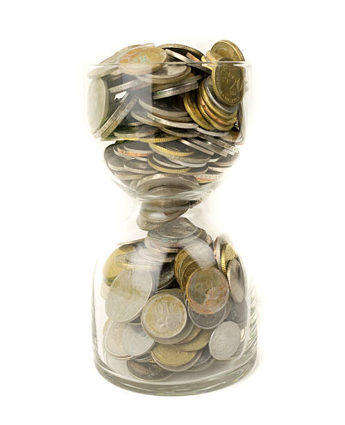 istock Malaysia gold coins in transparent hourglass.  Selective focus. 512893019