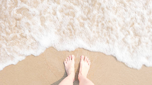 istock Top view foot on beach with Blur and soften foam 512893036