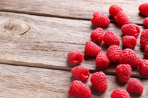 istock Red raspberries on grey wooden background 512903918