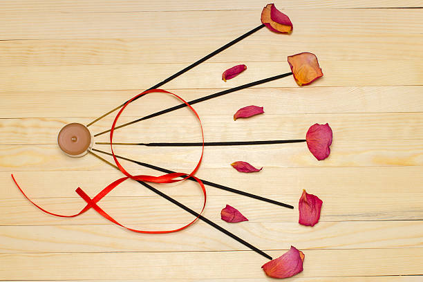 five incense sticks  and dry rose petal flat lay
