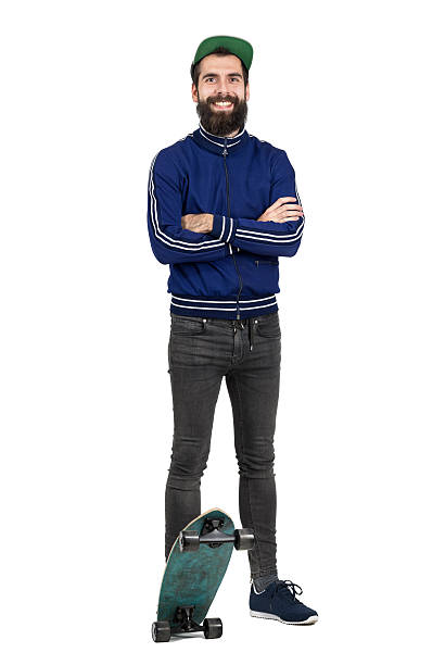 istock Happy hipster in tracksuit jacket and cap smiling at camera 512906412
