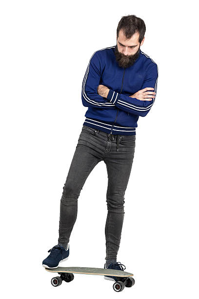 istock Punker standing on longboard looking down with crossed arms 512906482