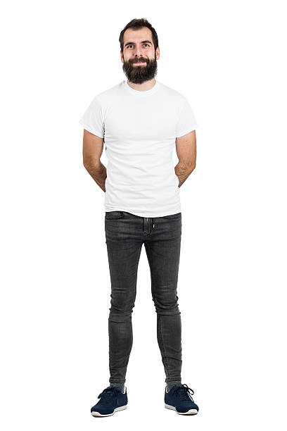 heureux homme barbu souriant avec les mains derrière le dos du t-shirt blanc - t shirt white men jeans photos et images de collection