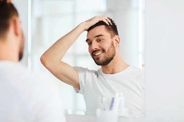 istock happy young man looking to mirror at home bathroom 512907414