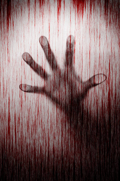 istock Blurry murderer hand behind matted glass with blood stain murder 512909188