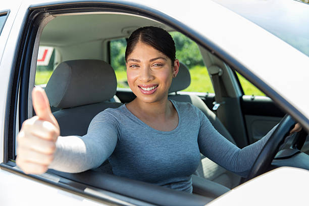 istock young female driver giving thumb up 512911984