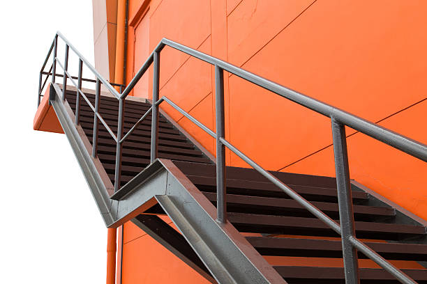 istock Metal fire escape on Orange Building With Isolated White Background 512917441