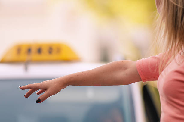 femme soulevant son bras pour appeler un taxi - car motor vehicle model land vehicle photos et images de collection