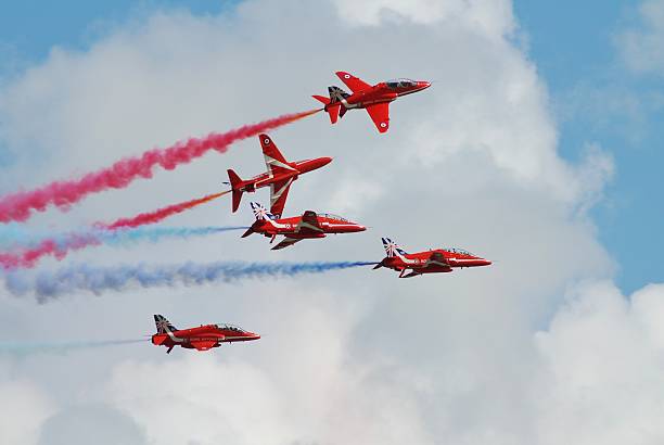 The Red Arrows team Eastbourne, England - August 14, 2014: RAF aerobatic team The Red Arrows perform at the annual free Airbourne airshow. Formed in 1965, the team are in their 50th display season. british aerospace stock pictures, royalty-free photos & images