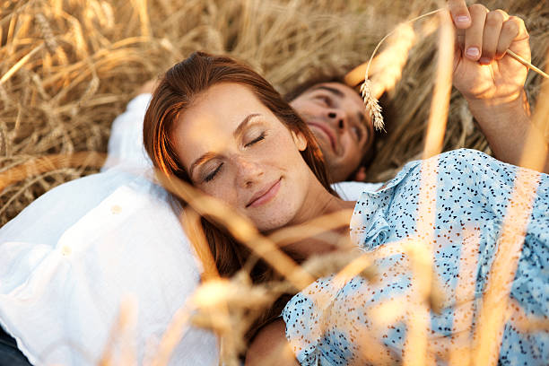 Cropped shot of an attractive young couple lying in a wheat field