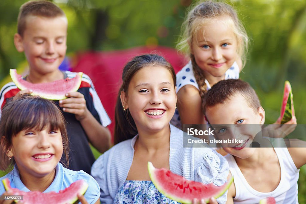 happy friends eating watermelon, outdoors Summer Camp Stock Photo