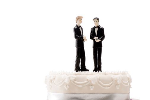 Studio still life  picture of a decorated wedding cake with two traditionally dressed male  figures on top of the cake.  Can be used vertically or horizontally with a  pure white background for lots of copy space./file_thumbview/46863952/1
