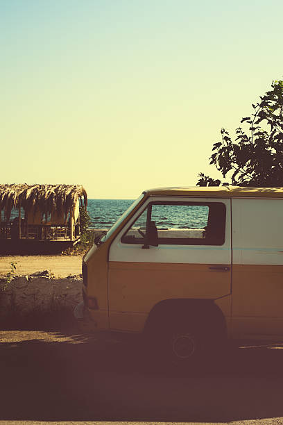 istock Grungy old microbus style van parked by ocean in summer 512937195