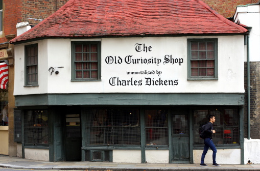 London, England - Sept 11, 2014: A man passes the windows of The Old Curiosity Shop in London, a 16th century building generally used for retail purposes. However, any connection with Charles Dickens is unproven.