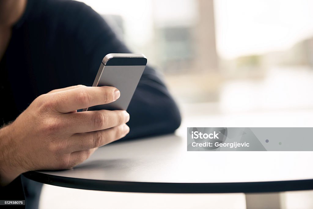 Typing on smartphone. Male hand typing on the smartphone indoor. Adult Stock Photo