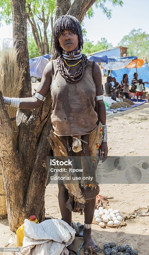 Hamar woman seller at village market. Turmi, Omo Valley, Ethiopia - December 30, 2013: Unidentified Hamar woman seller at village market. Weekly markets are important events in Omo Valley tribal life. Adult Stock Photo