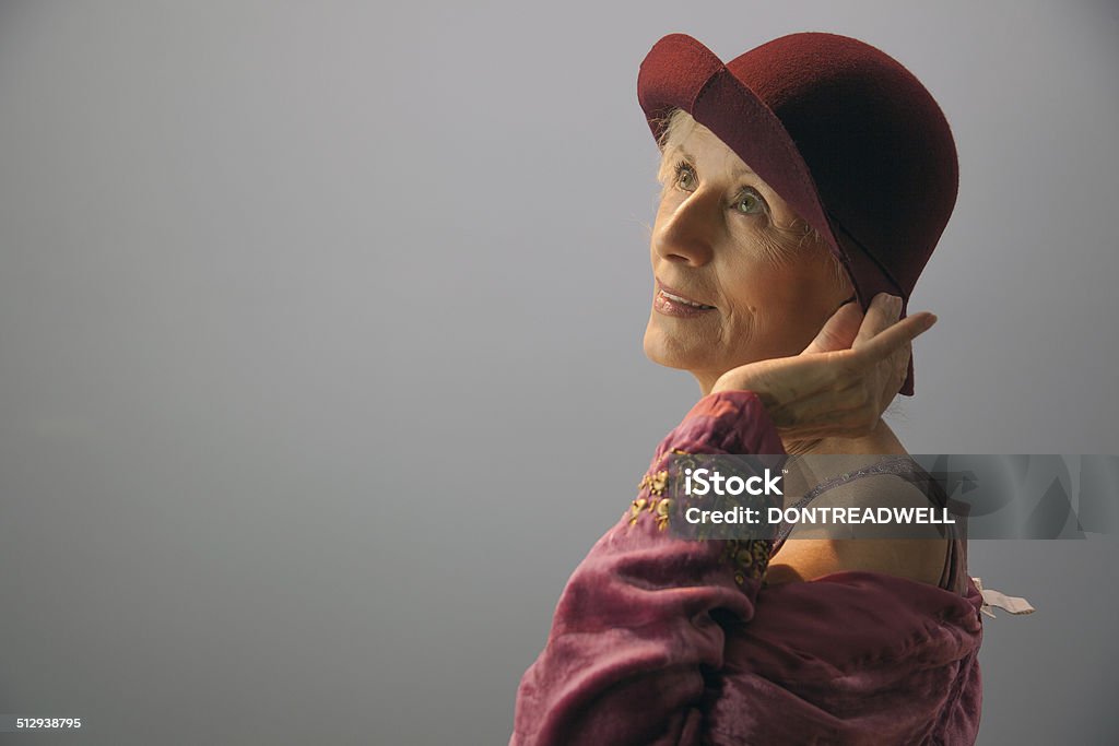 Senior Female Touching Her Hat This senior female is wearing a 1930's costume and touching the brim of her  hat 1930-1939 Stock Photo