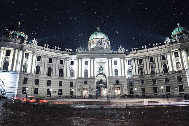 Christmas In Vienna Michaeltrakt, Hofburg in Vienna. Illuminated Hapsburg palace on snowy winter evening. the hofburg complex stock pictures, royalty-free photos & images
