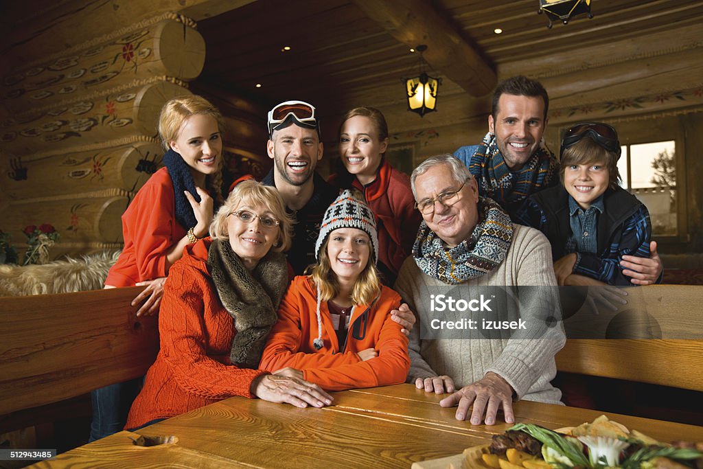 Family in mountain restaurant Portrait of multi-generation family sitting in a mountain restaurant after skiing, smiling at the camera. Family Stock Photo