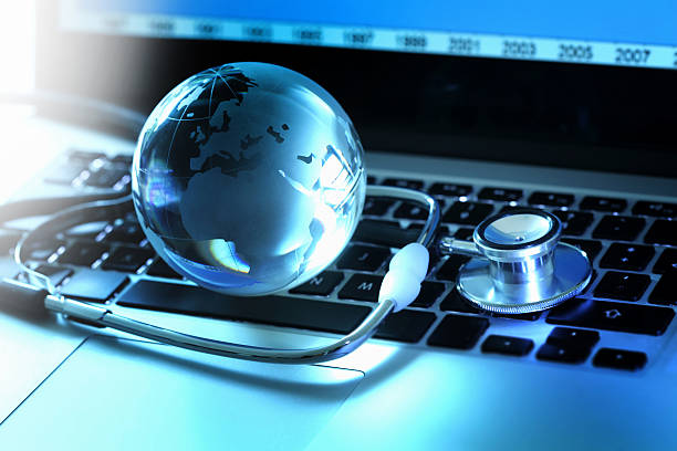 istock Stethoscope and globe on laptop keyboard 512958437