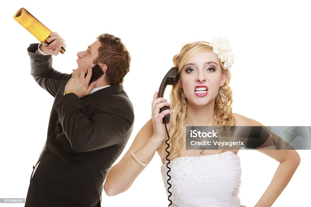 Wedding. Angry bride and groom talking on phone Wedding relationship difficulties. Angry woman and drunk man talking on the phone. Couple bride and groom quarelling isolated on white. Addiction and alcoholism. Addiction Stock Photo