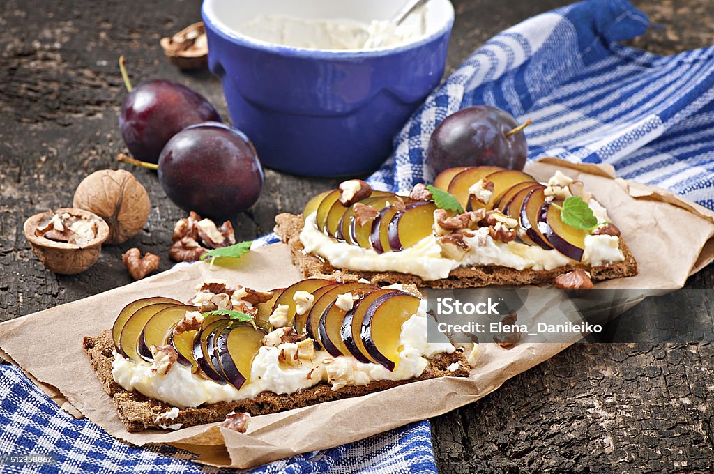 Vegetarian Diet sandwiches Crispbread Vegetarian Diet sandwiches Crispbread with cottage cheese, plums, nuts and honey on old wooden background Bruschetta Stock Photo