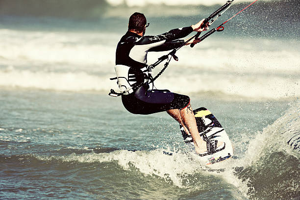 istock Muscular and masculine, a kiteboarder flies through the waves 512959359
