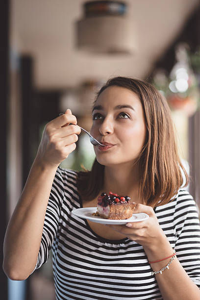 istock Young woman eating strawberry cheesecake 512963481