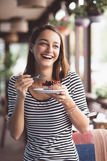 istock Young woman eating strawberry cheesecake 512963647