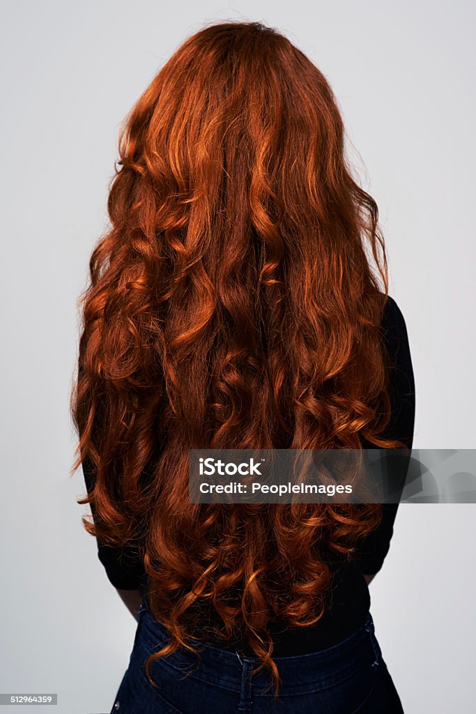 Grow it long and strong Studio shot of a young woman with beautiful red hair posing against a gray background Rear View Stock Photo