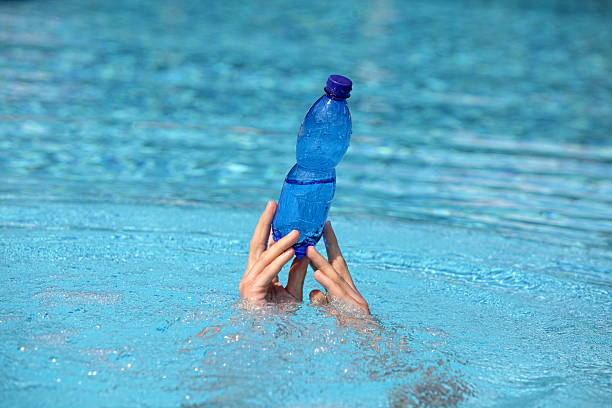 istock two hands holding plastic bottle of water above  water 512965302