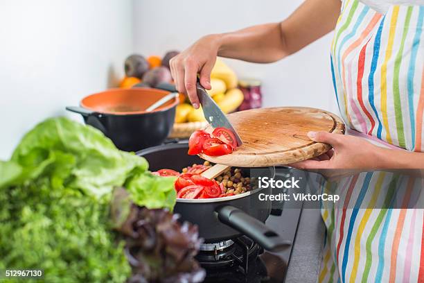 Young Woman Cooking In Her Modern Kitchen Stock Photo - Download Image Now - Adult, Adults Only, Apartment